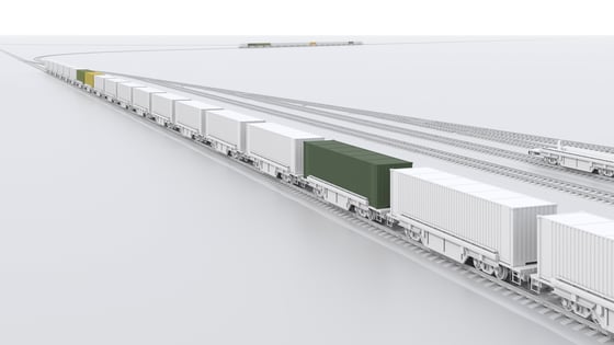 A loaded freight train runs over rails.